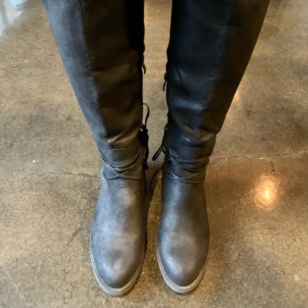 Women’s knee high black boots with laces.